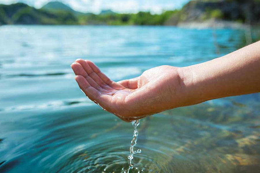 Hand cupping water at a lake